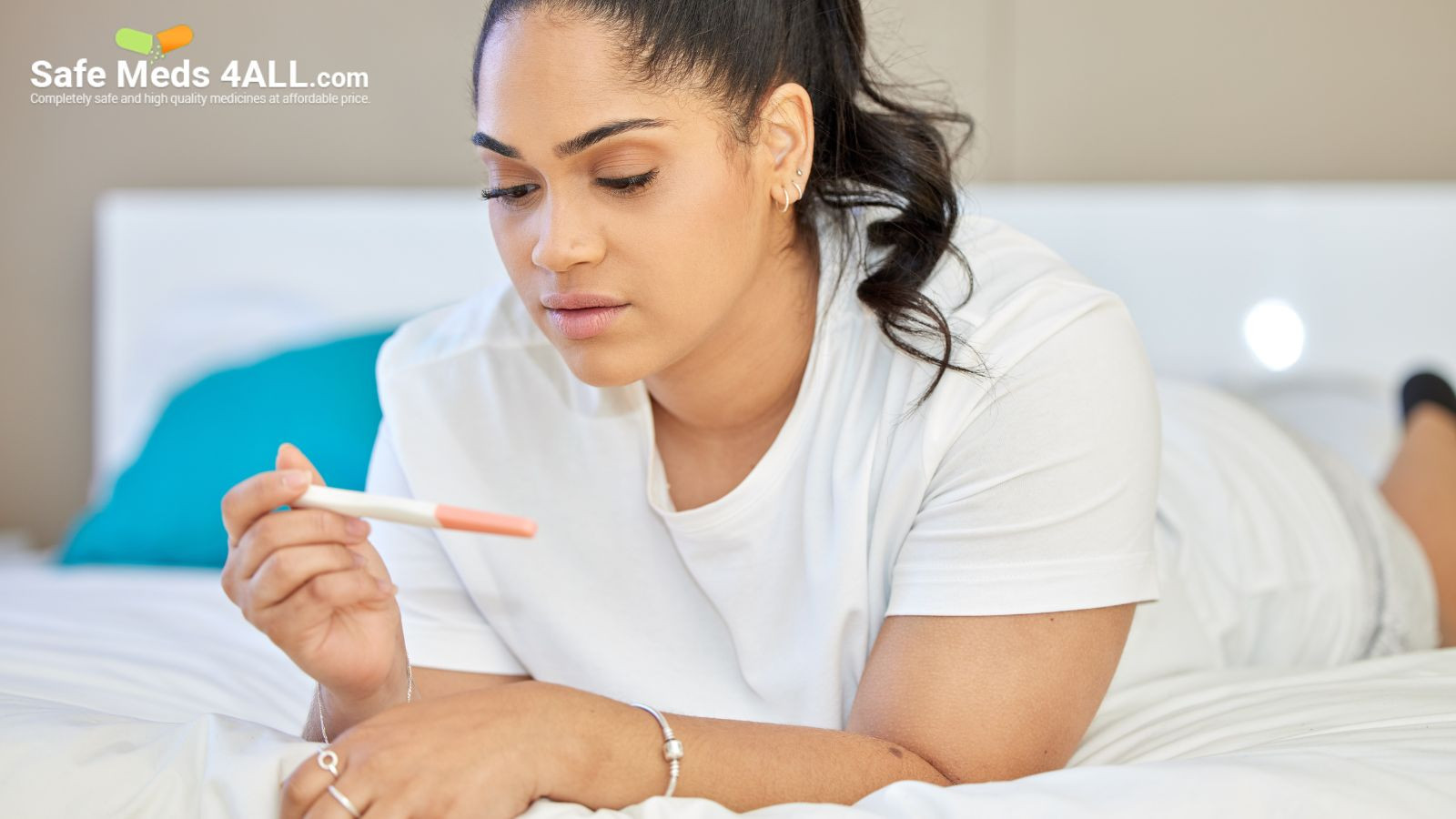 A girl on lying on bed,  seeing results of pregnancy test  on pregnancy test kit.